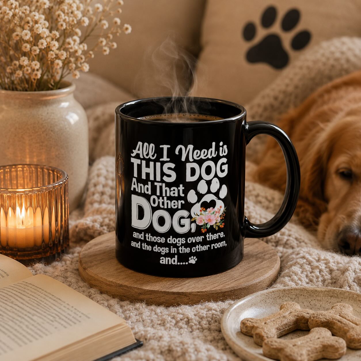 All I Need is This Dog and That Other Dog black mug styled with book, candle, dried flowers, and a golden retriever resting nearby