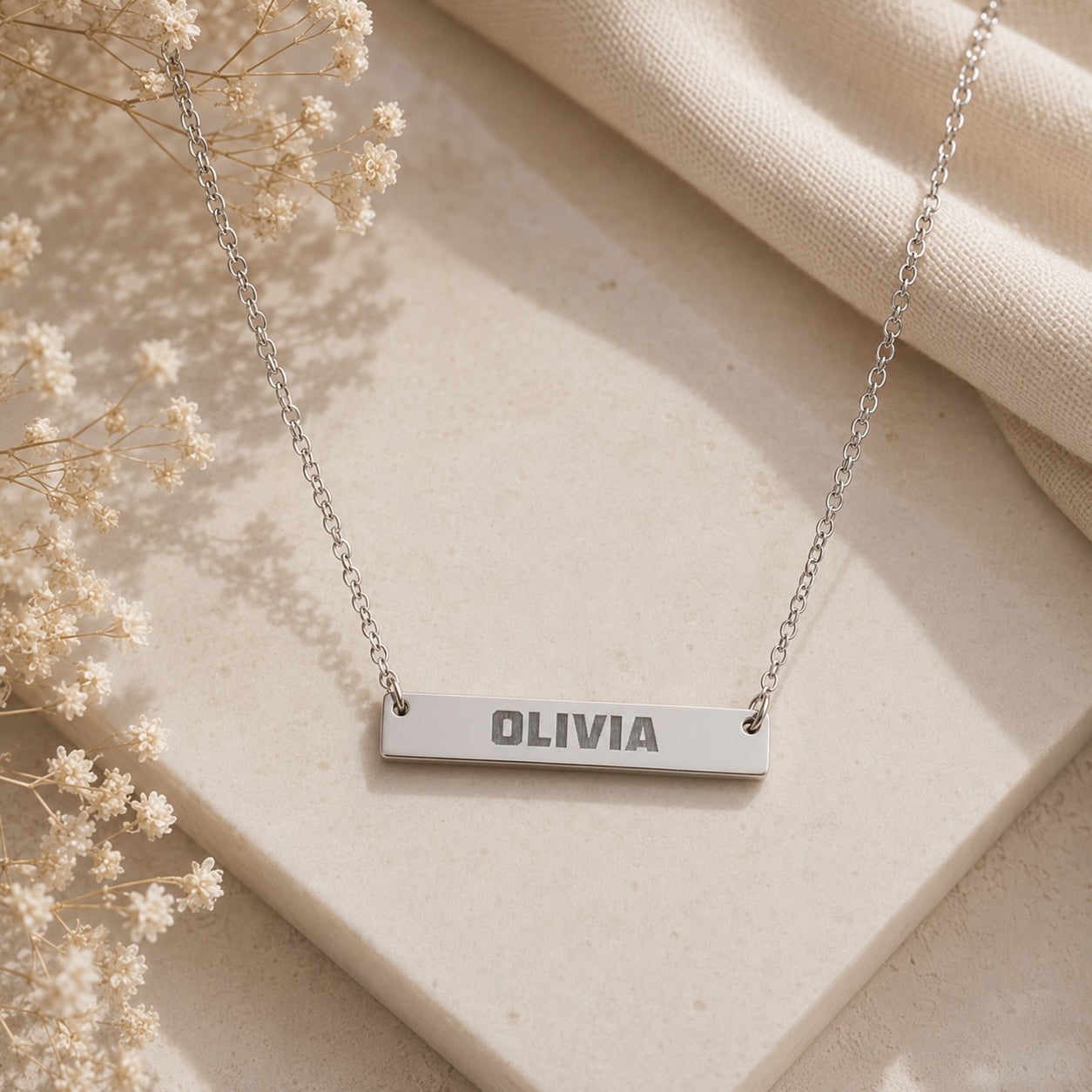 Brushed bar necklace close-up of bold font engraved name