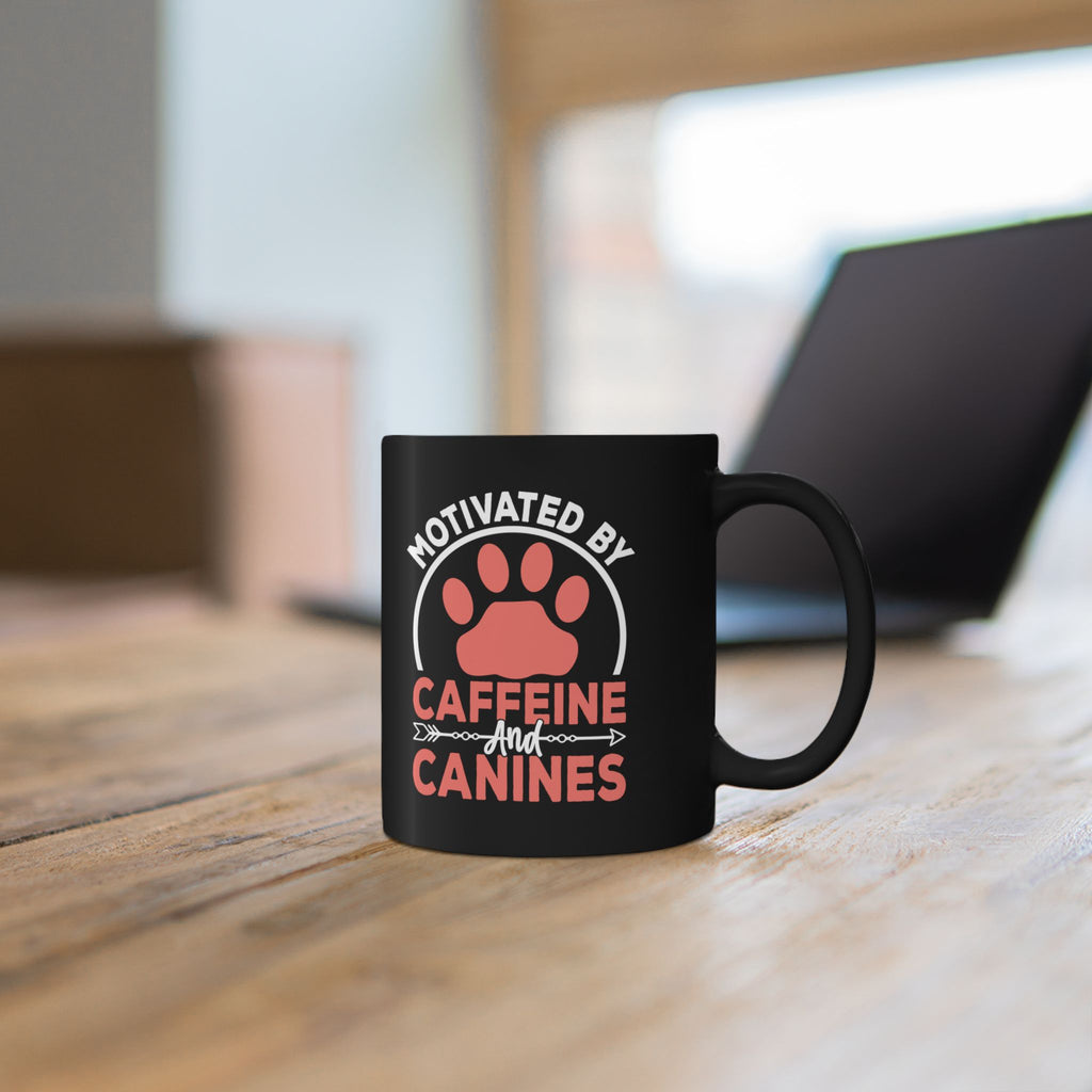 Close-up of Motivated by Caffeine and Canines design on black mug