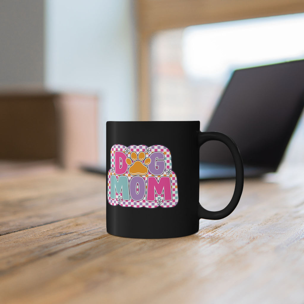 Close-up of retro checkerboard Dog Mom design on black mug