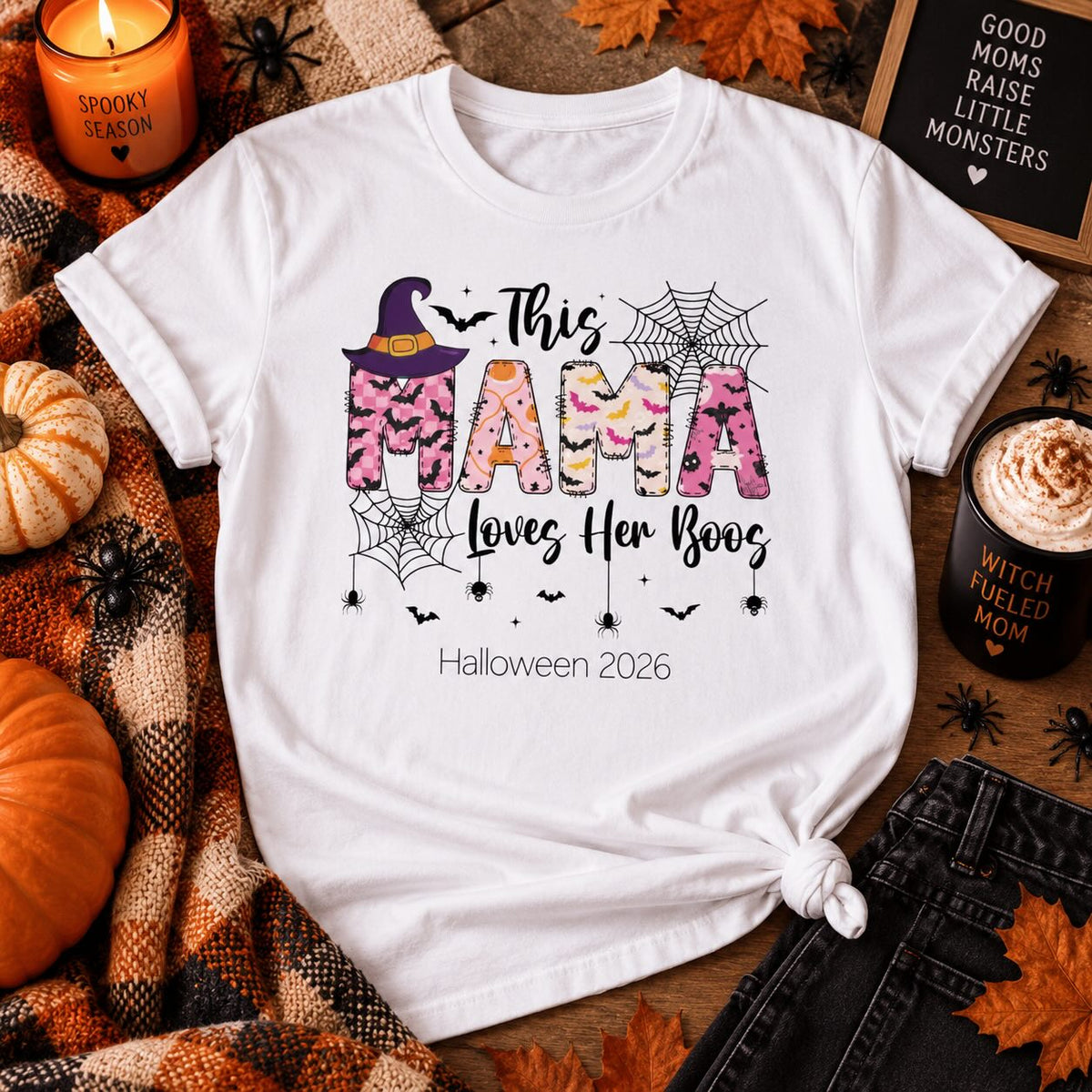 This Mama Loves Her Boos Halloween t-shirt styled flat lay with pumpkins, candle, and fall props