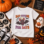 Toddler wearing personalized Bat-titude Halloween t-shirt, back view showing custom name